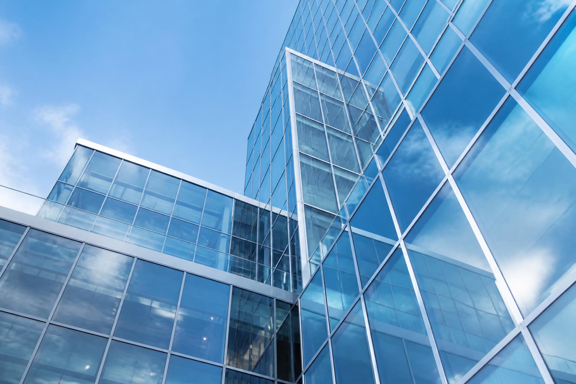 Modern glass façade with aluminium curtain wall reflecting the sky